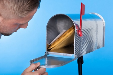 man opening mailbox with direct mail